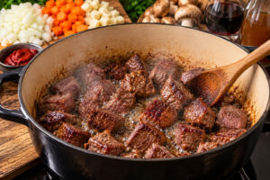 Rehfleisch für Rehgulasch kräftig im Bräter anbraten